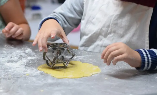 Children cutting out pastry shapes.